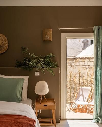 - une chambre avec un lit et une porte donnant sur une terrasse dans l'établissement La Fugue, Demeure Historique proche de Uzes,Nimes,Cévennes, à Brignon