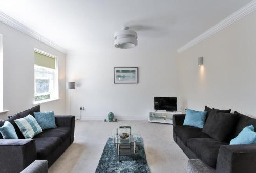 a living room with two couches and a tv at KVM - Jubilee Mansions Apartment by KVM Stays in Peterborough