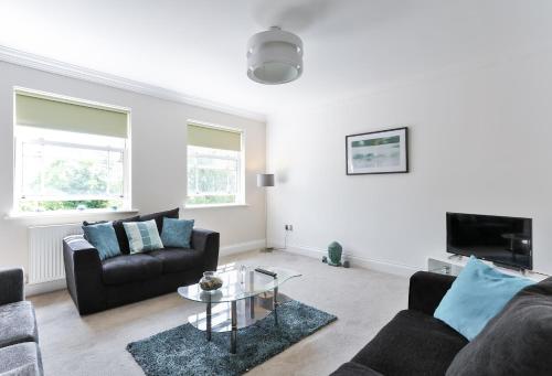 a living room with two couches and a table at KVM - Jubilee Mansions Apartment by KVM Stays in Peterborough