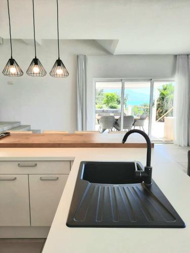 a kitchen with a sink with a view of the ocean at 5 stars 2 bedrooms villa BLUE DREAM village Pisak Croatia in Pisak