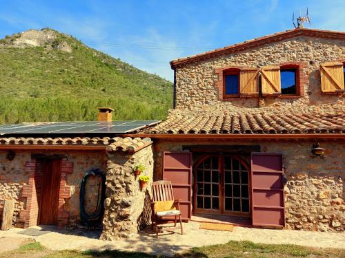 a stone house with a chair in front of it at Corral d'en Romagosa in Barcelona