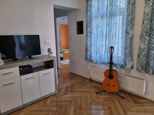 a living room with a guitar and a television at Apartman Nataly in Varaždin