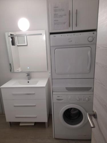 a bathroom with a washing machine and a sink at Apartments Las Vinas in Denia