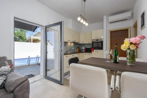 a kitchen and dining room with a table and chairs at Apartment Vedran with pool, near Porec in Kukci