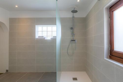 um chuveiro com uma porta de vidro na casa de banho em Les Pimprenelles em Carcassonne