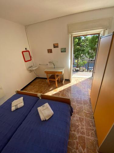 a room with a bed and a table and a bathroom at Appartamenti NeMoZo Moretti in Ponzone