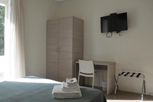 a bedroom with a bed and a desk and a tv at Hotel Riva e Mare in Rimini