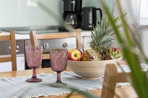 a table with two wine glasses and a bowl of fruit at Apartment Josipa in Split