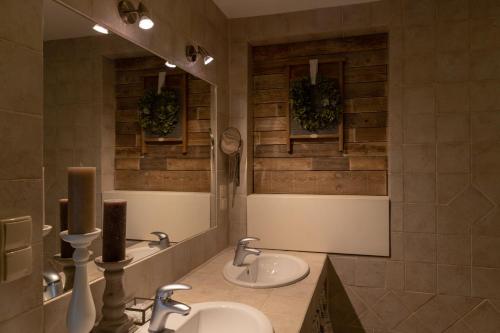 ein Badezimmer mit zwei Waschbecken und zwei Spiegeln in der Unterkunft Cottage on the Hill in Kielno