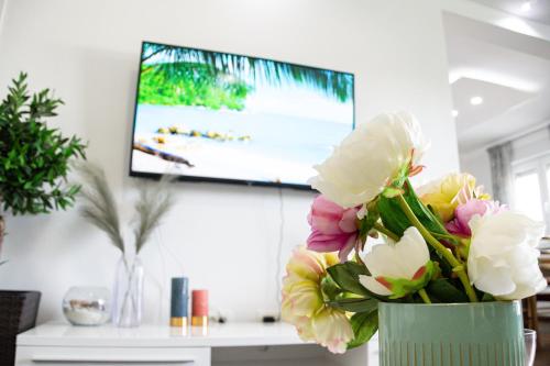 a vase filled with flowers in front of a tv at Apartment Josipa in Split