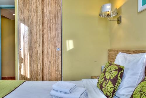 une chambre avec un lit avec un oreiller et une fenêtre dans l'établissement Appartement Port Prestige - terrasse - piscine - parking, à Antibes