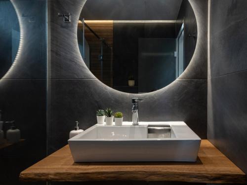 een badkamer met een witte wastafel en een spiegel bij Aloe The Green Suites - Nikiti Halkidiki in Nikiti