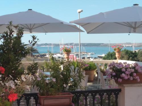 a balcony with potted plants and umbrellas at Antico Palazzo Spinola in Gallipoli