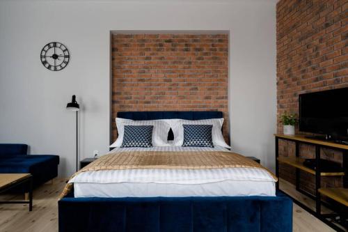 una camera con un grande letto con un muro di mattoni di Apartament w ścisłym centrum miasta. a Lublino