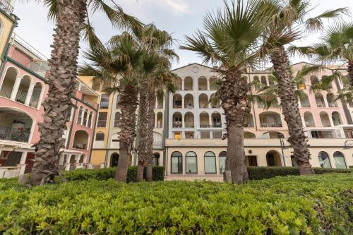 a row of palm trees in front of a building at Soleblu in Porto Recanati