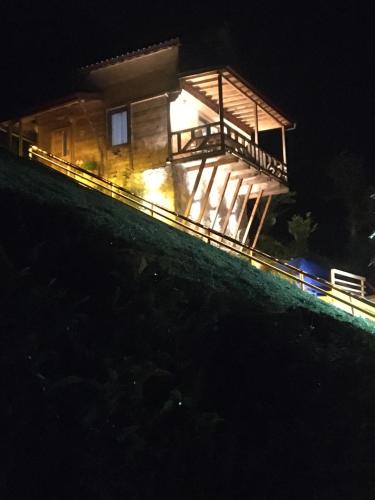 a house lit up at night on a hill at Vadi dağ evi bungalov in Çamlıhemşin