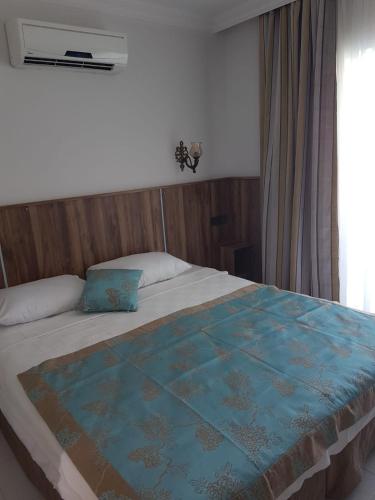 a bedroom with a bed with a blue quilt on it at Elijah Hotel in Kemer