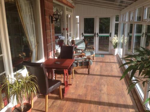a screened in porch with chairs and a table at Edenhall Country Hotel in Penrith