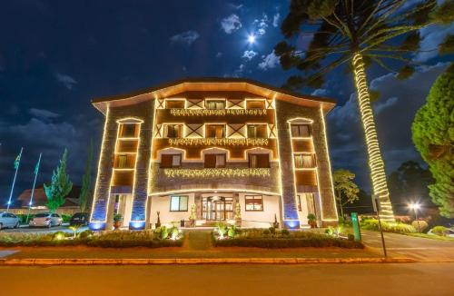 a building with a palm tree in front of it at Flat em Gramado in Gramado