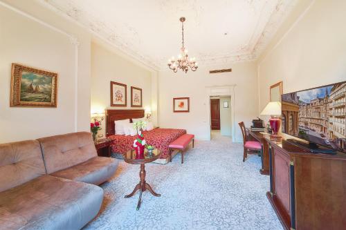 a living room with a couch and a tv at Carlsbad Plaza Medical Spa & Wellness hotel in Karlovy Vary