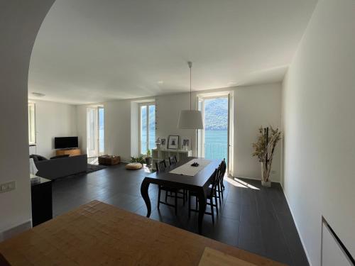 a dining room and living room with a table and chairs at Lugano Lake, nido del cigno in Oria