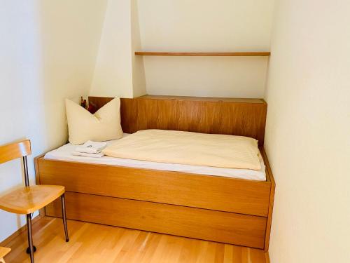 - un lit dans une petite chambre avec une tête de lit en bois dans l'établissement Villa Schlossbauer - Ferienwohnung 13, à Heringsdorf