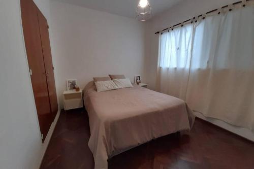 - une chambre blanche avec un lit dans l'établissement Excelente ubicación en el Bv. más lindo de Rosario, à Rosario