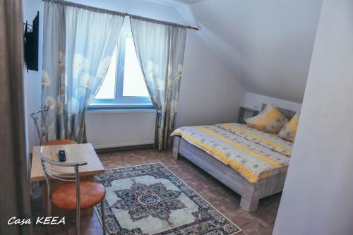 a small bedroom with a bed and a window at Casa Keea in Moieciu de Sus