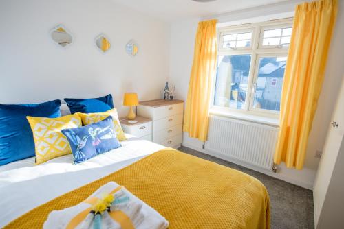 een slaapkamer met een bed met een gele deken en een raam bij KVM - Sunshine Apartment by KVM Stays in Peterborough
