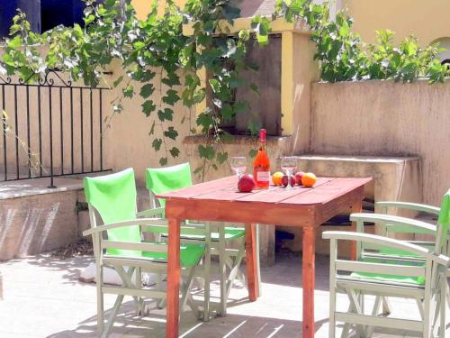 a wooden table with chairs and a bottle of wine at Dourios Ippos Apartments in Frikes