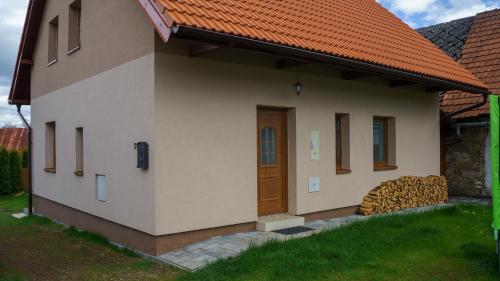 a house with a door and a pile of logs at Chalupa Kadov in Sněžné