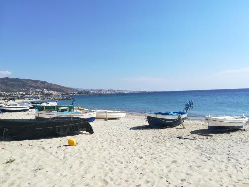 a group of boats sitting on a sandy beach at Casa Silipi in Gallico