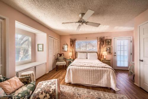 a bedroom with a bed and a couch and windows at Binky's Nest in Fredericksburg