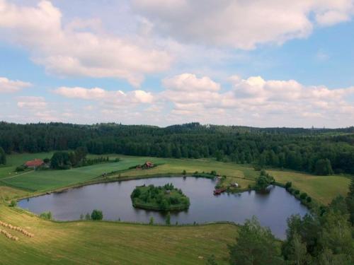 an island in the middle of a lake in a field at Domek letniskowy Rancho do wynajęcia 7osobowy Rybaczówka in Banie Mazurskie