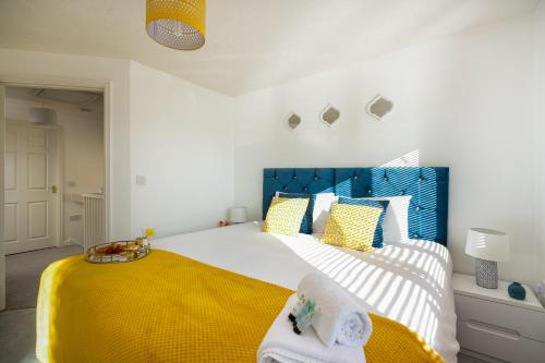 a bedroom with a large bed with a yellow blanket at KVM - Whitebeam House great location by KVM Stays in Peterborough