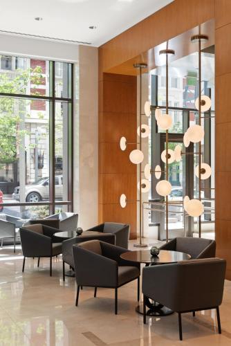 a lobby with chairs and tables and windows at Four Seasons Hotel Denver in Denver