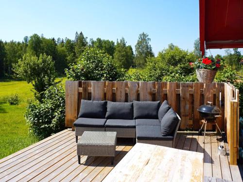 a patio with a couch and a table on a deck at 5 person holiday home in Mell sa in Mellösa