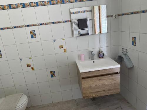 łazienka z umywalką i lustrem w obiekcie Gimi Vendégház w mieście Baja