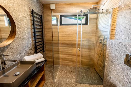 a bathroom with a glass shower and a sink at Trzy Rybki - Belona dom z basenem i jacuzzi in Puck