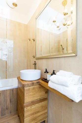 a bathroom with a sink and a mirror and a tub at Royal Castle Square Apartment Old Town Warsaw Warszawa in Warsaw