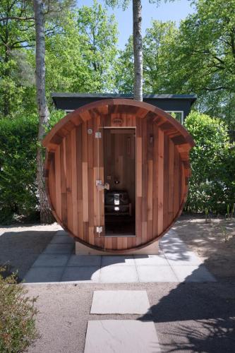 a wooden building with a door in the middle at ZEN-bungalow NO 2 met sauna en hottub in Rheezerveen