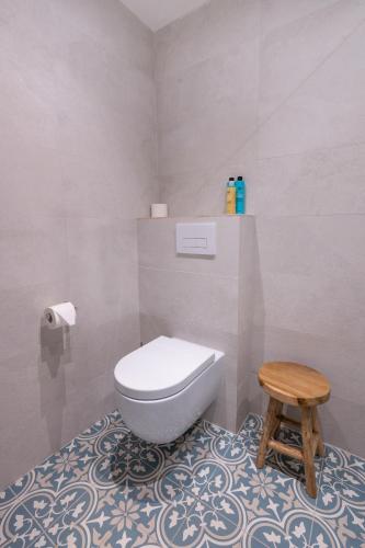 a bathroom with a toilet and a wooden stool at ZEN-bungalow NO 2 met sauna en hottub in Rheezerveen
