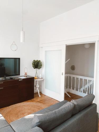 a living room with a couch and a tv at VillaMar Figueira da Foz in Figueira da Foz