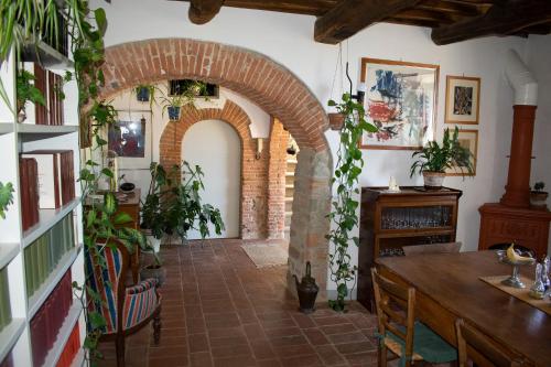a dining room with an archway and a table with plants at Villa Gioietta in Strada