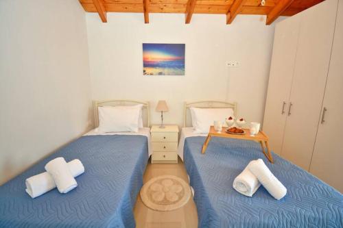 Drosáton的住宿－Casa Lydia Drosato Corfu，卧室设有两张单人床和一张桌子