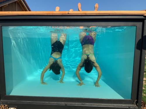 two people in the water in a swimming pool at L'ADRET DU TEMPS CHALET 10 PERSONNES 170m2 in Gérardmer