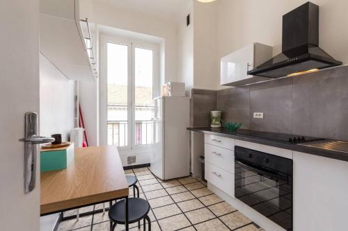 une cuisine avec une table et une cuisinière four supérieur dans l'établissement FEEL HOME - ASSALIT, à Nice