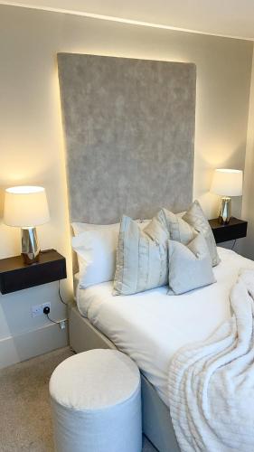 a bedroom with a bed with two lamps and a stool at NOVU Apartments Liverpool Waterfront in Liverpool