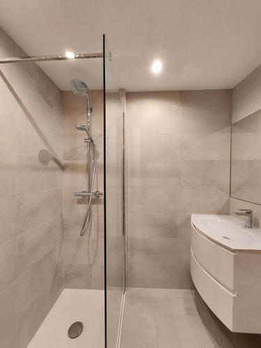 uma casa de banho com um chuveiro e um lavatório. em ARC 1800, Résidence les Lauzieres em Arc 1800