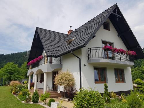 a white house with a black roof at Domki i Pokoje u Ilony in Krościenko